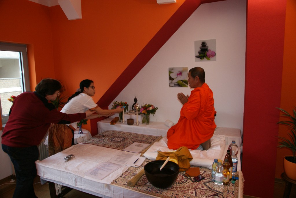 Ein Bouddhist Mönch gibt einen Segen für den Salon